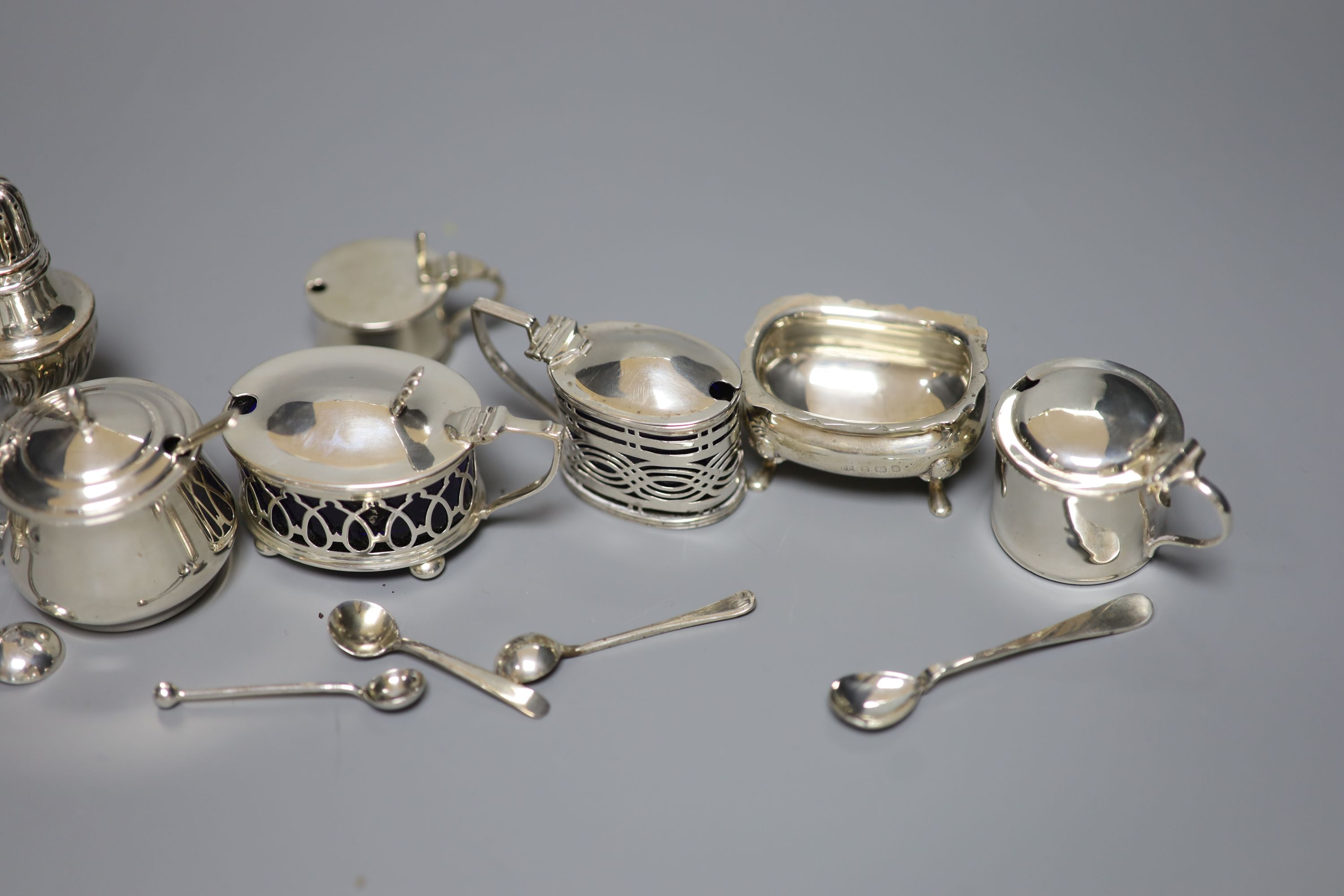 A pair of oval silver salts and spoons, nine small silver mustards, a pepper and seven various condiment spoons, approx 11.5oz
